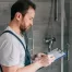 Plumber inspecting a homeowner's bathroom.