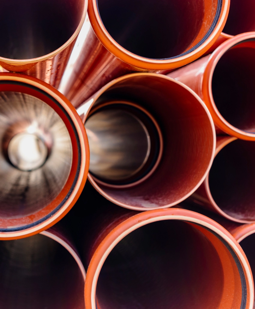 Orange sewer pipes stacked on top of one another.